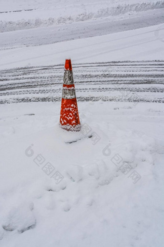 警告橙色锥冰冷的路转车轮胎痕迹雪路