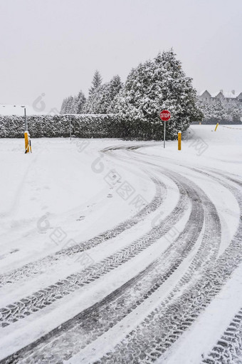 冬天轮胎痕迹雪路转停止标志前面