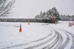 冬天轮胎痕迹雪路转停止标志前面