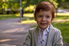 可爱的红色头发的人微笑男孩公园