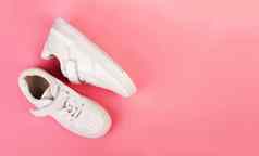 一对白色皮革运动鞋孤立的粉红色的背景