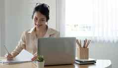 快乐年轻的亚洲业务女人企业家电脑屏幕工作互联网坐办公室桌子上微笑女专业员工打字电子邮件移动PC工作场所