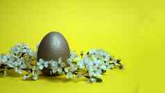 金蛋开花分支黄色的背景复活节概念