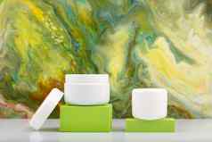 白色化妆品罐子绿色领奖台绿色大理石的背景复制空间