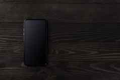 现代智能手机黑色的木表格