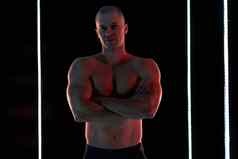 活跃的生活方式概念专业健美运动员显示完美的肌肉发达的身体灯照明背景