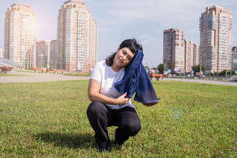 高级女人擦拭汗水硬锻炼在户外公园