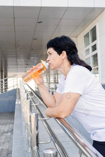 <strong>高级</strong>女人喝水锻炼在户外城市<strong>背景</strong>