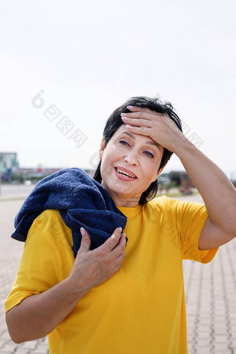 微笑高级女人擦拭<strong>汗水</strong>硬锻炼在户外公园