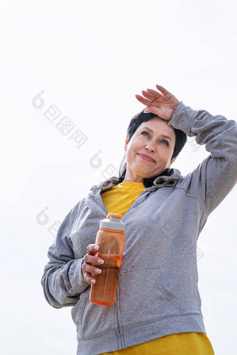 高级女人擦拭汗水硬锻炼在户外公园