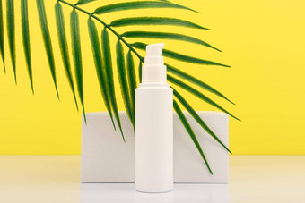 夏天脸奶油防晒系数白色几何讲台上棕榈叶黄色的背景概念防晒霜