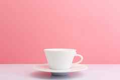 白色陶瓷咖啡杯飞碟白色表格光粉红色的背景复制空间