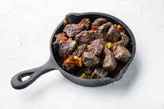 牛肉肉红烧土豆胡萝卜香料投铁煎锅白色石头表面