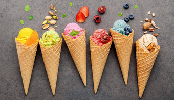 冰奶油味道视锥细胞蓝莓草莓阿月浑子杏仁橙色樱桃设置黑暗石头背景夏天甜蜜的菜单概念