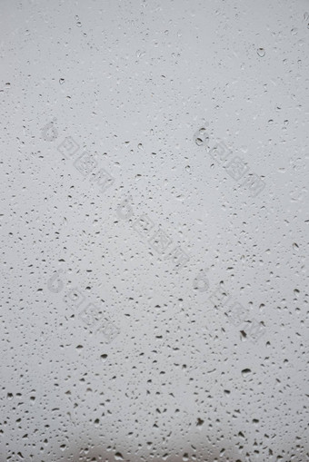 湿水滴玻璃窗口光灰色多雨的背景特写镜头