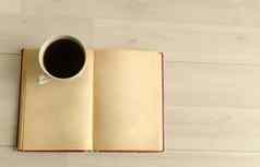 杯咖啡开放书白色木背景前视图空间文本