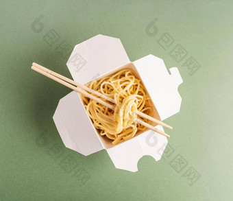 打开锅纸盒子面条筷子前视图平躺绿色背景