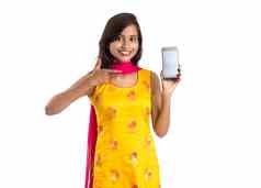 年轻的美丽的女人持有显示空白屏幕智能手机移动平板电脑电话白色背景