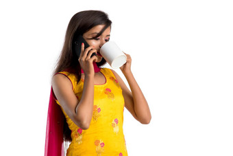 漂亮的年轻的女孩调用智能手机设备喝美味的咖啡<strong>茶饮</strong>料