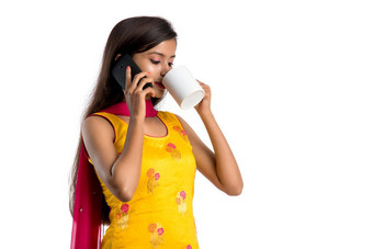 漂亮的年轻的女孩调用智能手机设备喝美味的咖啡<strong>茶饮料</strong>