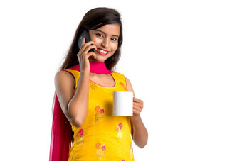 漂亮的年轻的女孩调用智能手机设备喝美味的咖啡茶饮料