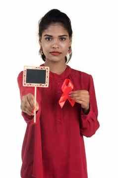 年轻的女人显示红色的丝带艾滋病毒艾滋病意识丝带医疗保健医学概念