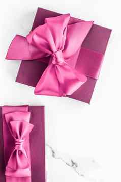 粉红色的礼物盒子丝绸弓大理石背景女孩婴儿淋浴现在魅力时尚礼物奢侈品美品牌假期平铺艺术设计