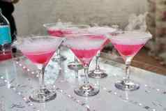 玻璃拍摄眼镜热气腾腾的粉红色的鸡尾酒樱桃底