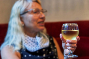 上了年纪的女人玻璃白色酒手焦点酒玻璃