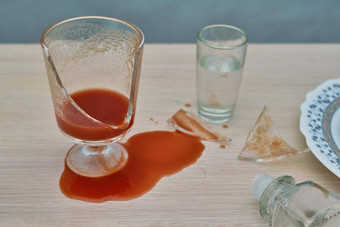 破碎的玻璃红色的番茄汁泄漏表格瓶伏特加