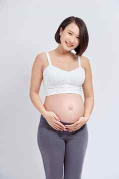 美丽的亚洲怀孕了女人期待婴儿触碰肚子