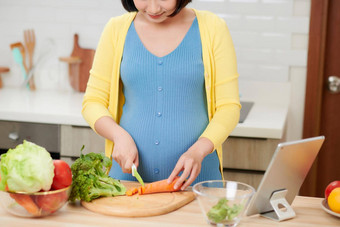 美丽的微笑年轻的怀孕了女人准备健康的食物很多<strong>水果</strong>蔬菜<strong>首页</strong>厨房