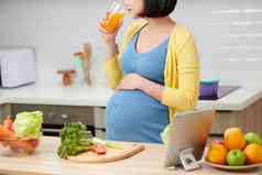 怀孕了女人厨房喝健康的水果汁