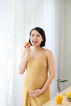 怀孕了美丽的女孩持有苹果需要好护理吃健康的食物