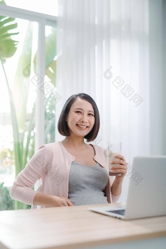 年轻的美快乐亚洲怀孕了女人持有玻璃<strong>牛奶</strong>电脑<strong>首页</strong>