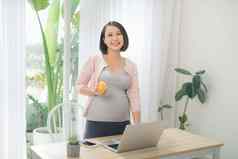 年轻的怀孕了女人快乐吃苹果