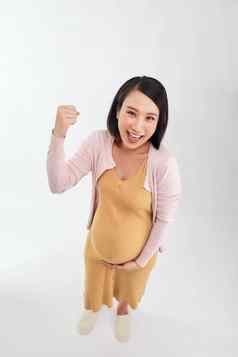 年轻的美丽的怀孕了女人庆祝胜利成功兴奋提高了手臂