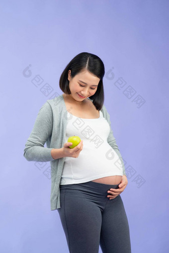 <strong>图片</strong>快乐年轻的怀孕了亚洲女人站孤立的<strong>紫色</strong>的背景相机持有苹果