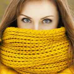 漂亮的女人黄色的针织围巾相机美丽的眼睛凝视