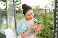 绿色植物能美丽的快乐亚洲女人手阳台公寓早....