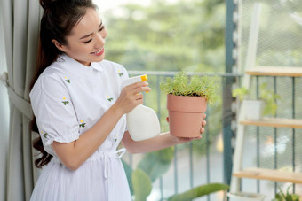 女人浇水喷涂<strong>首页</strong>植物概念<strong>首页</strong>花园<strong>春</strong>天时间采取护理<strong>首页</strong>植物