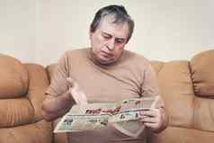 男人。年龄阅读新闻报纸坐着沙发上