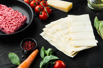 意大利厨房食物烹饪成分烤宽面条意大利面帕尔玛奶酪调味料黑色的木表格背景