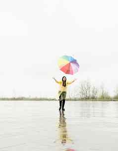 有趣的女人捕捉色彩斑斓的伞在户外雨