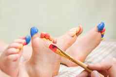 只脚孩子们艺术发展游戏画油漆腿孩子婴儿艺术治疗孩子画腿孩子们色彩斑斓的油漆关闭手刷绘画脚孩子们感觉玩有趣的脚趾