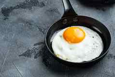 炸鸡蛋樱桃西红柿面包早餐投铁煎锅灰色的背景空间文本Copyspace