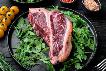 烹饪肉背景生岁的牛肉丁字牛排牛排香料草本植物烧烤黑色的木表格背景