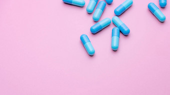 蓝色的胶囊药片粉红色的背景蓝色的胶囊药片复制空间制药行业社区药店产品药物怀孕女人泌乳上了年纪的人主题