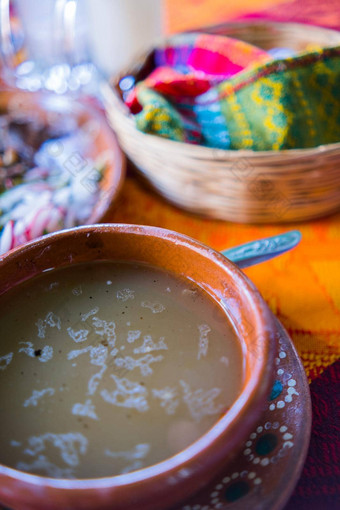 传统的墨西哥羊肉肉汤玉米粉圆饼篮子色彩斑斓的桌布