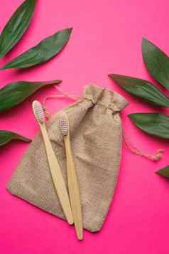 竹子牙刷帆布袋粉红色的背景绿色叶子生态产品塑料健康医学牙科刷牙牙齿复制空间文章采取护理环境文章刷牙牙齿